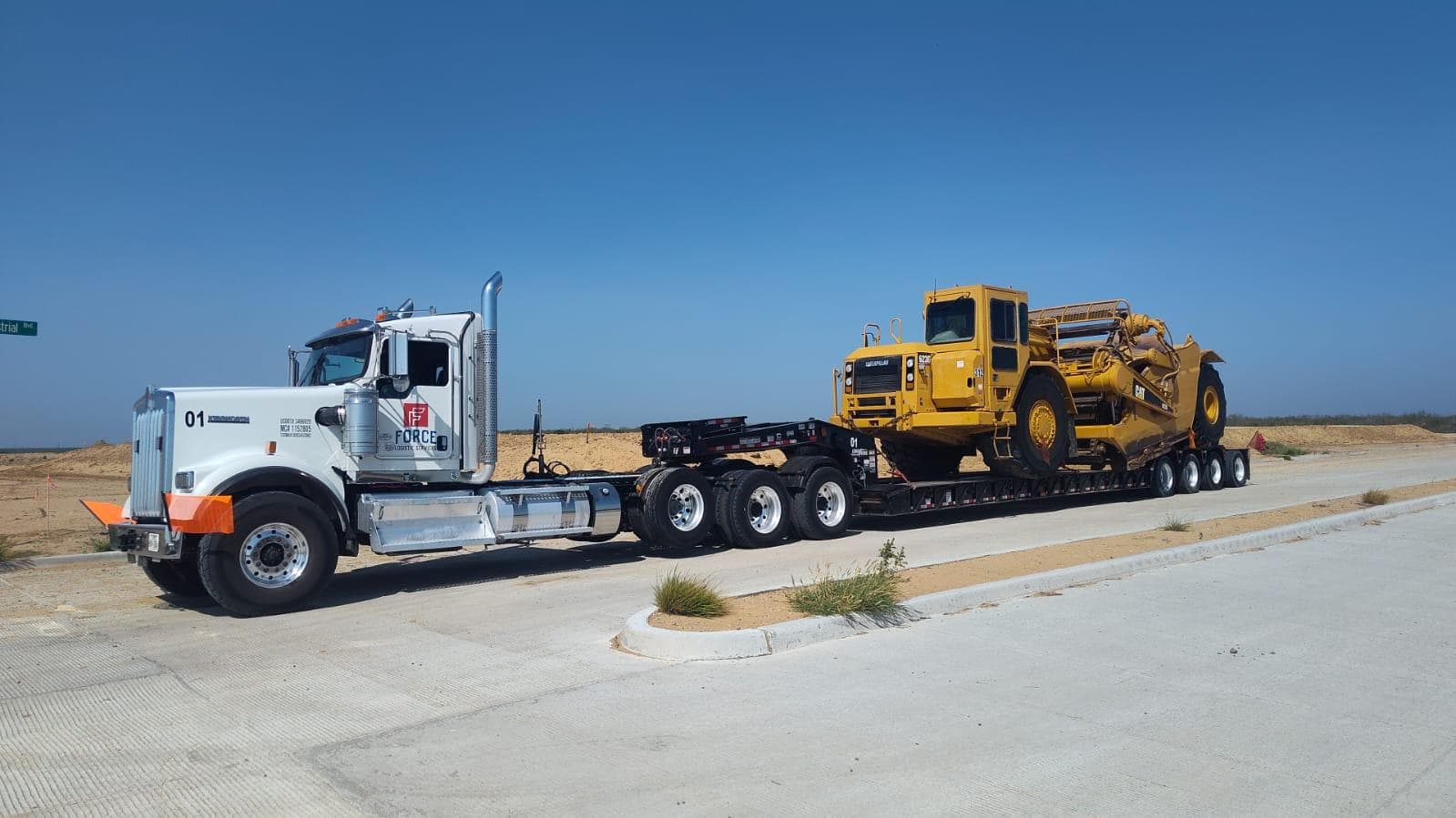 Force Kenworth W900 hauling CAT scraper on Texas highway