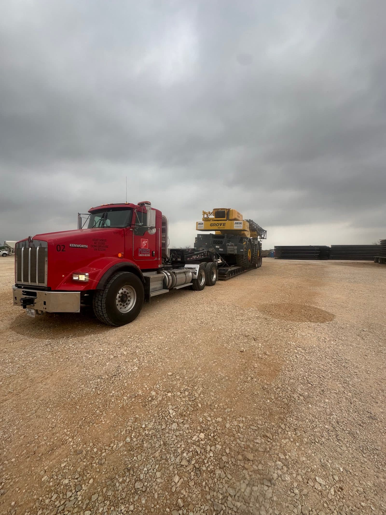Force red 2009 Kenworth T800 day cab, unit 02, hauling a Grove crane